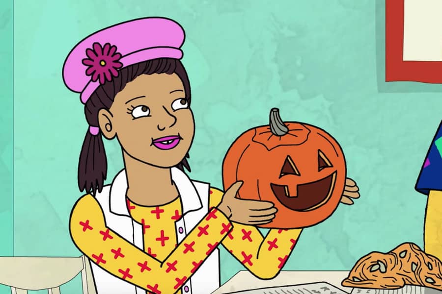 girl shows off a carved pumpkin